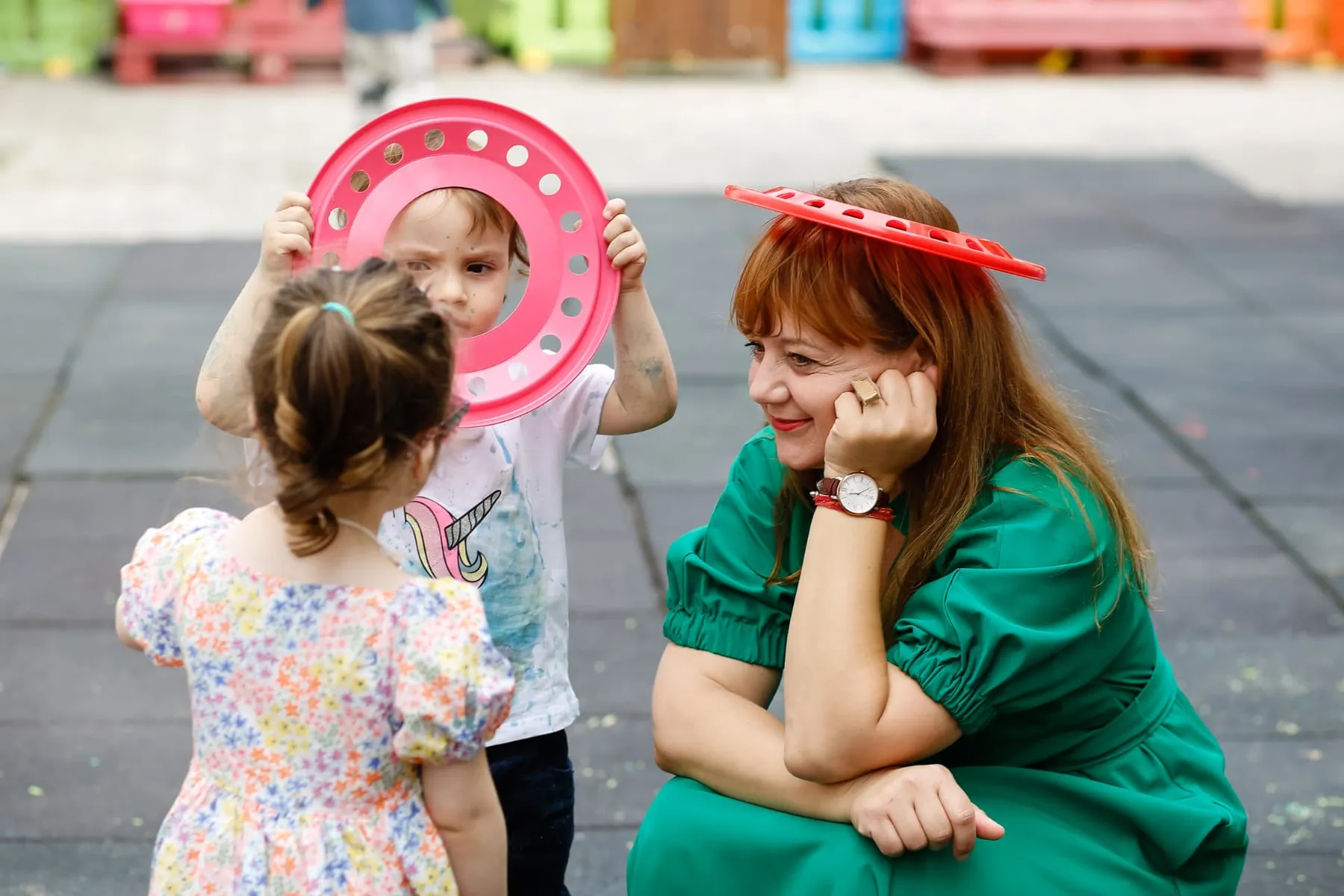 Educator Acorns Nursery jucându-se cu doi copii în curtea grădiniței